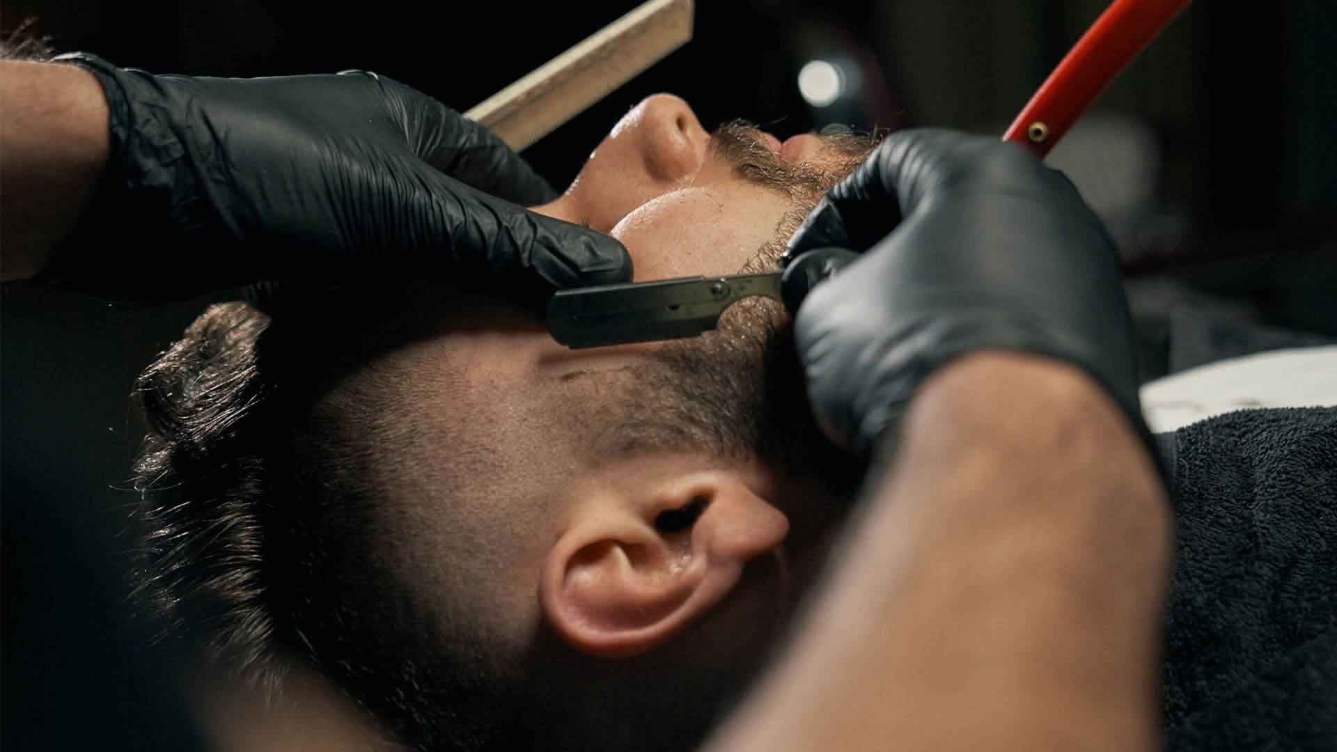 Barber trimming a client's beard